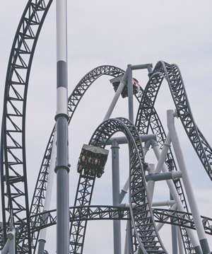 Picture of people upside down on a looping and twisting roller coaster